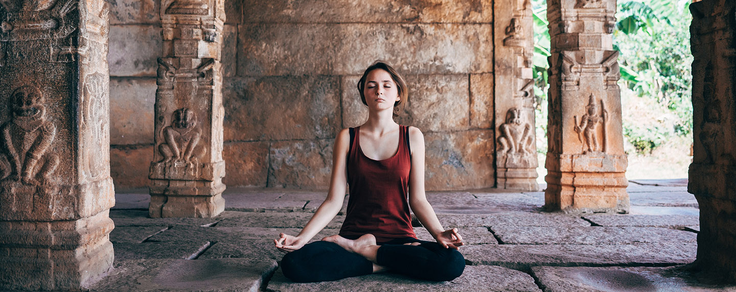 Woman doing yoga in Vishnu temple in Hampi, India